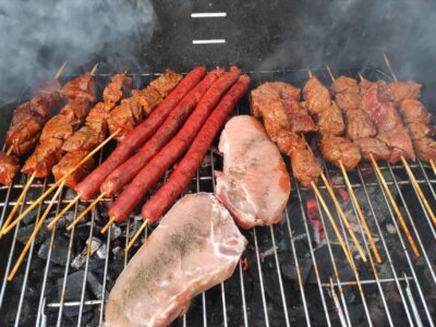 A variety of meats being grilled on a charcoal barbecue. — ventajas y cómo usarlas