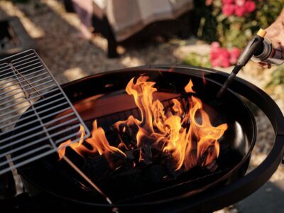 A charcoal grill ignited with flames using a torch. Perfect for outdoor barbecues. — carbón o eléctrica: cuál te conviene