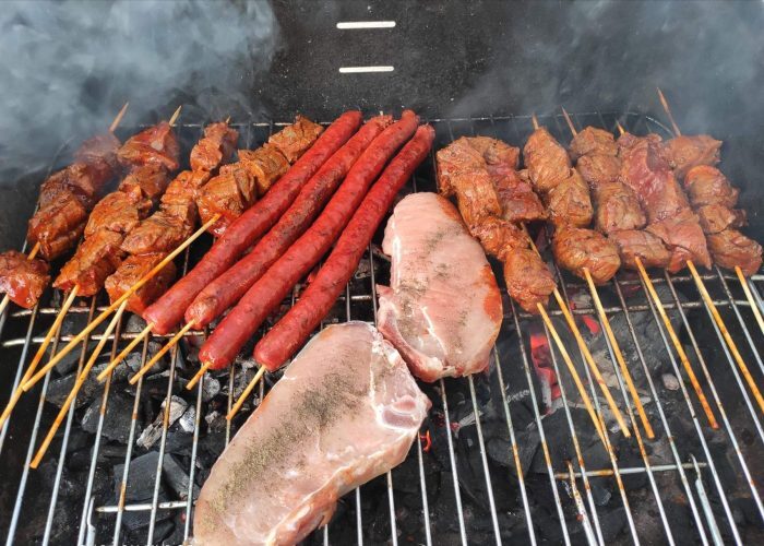 A variety of meats being grilled on a charcoal barbecue. — ventajas y cómo usarlas